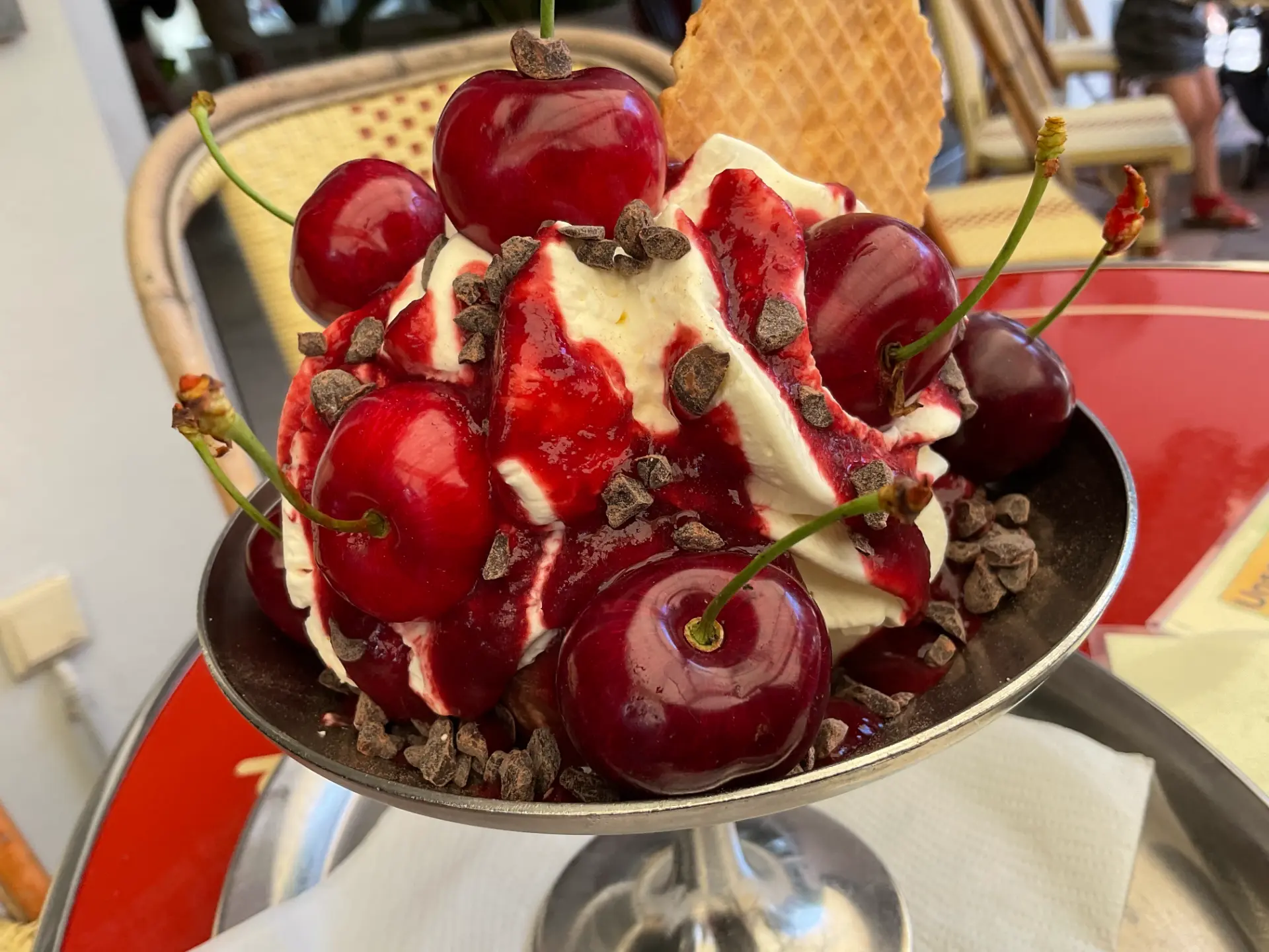 Eisbecher mit Sahne, frischen Kirschen und Schokoraspeln